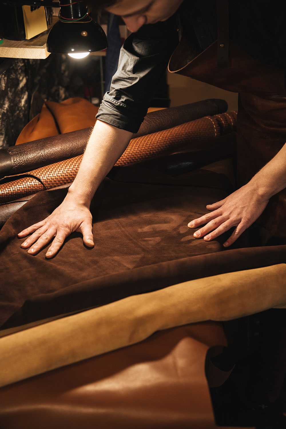 Young leather craftsman concentrating on his work.