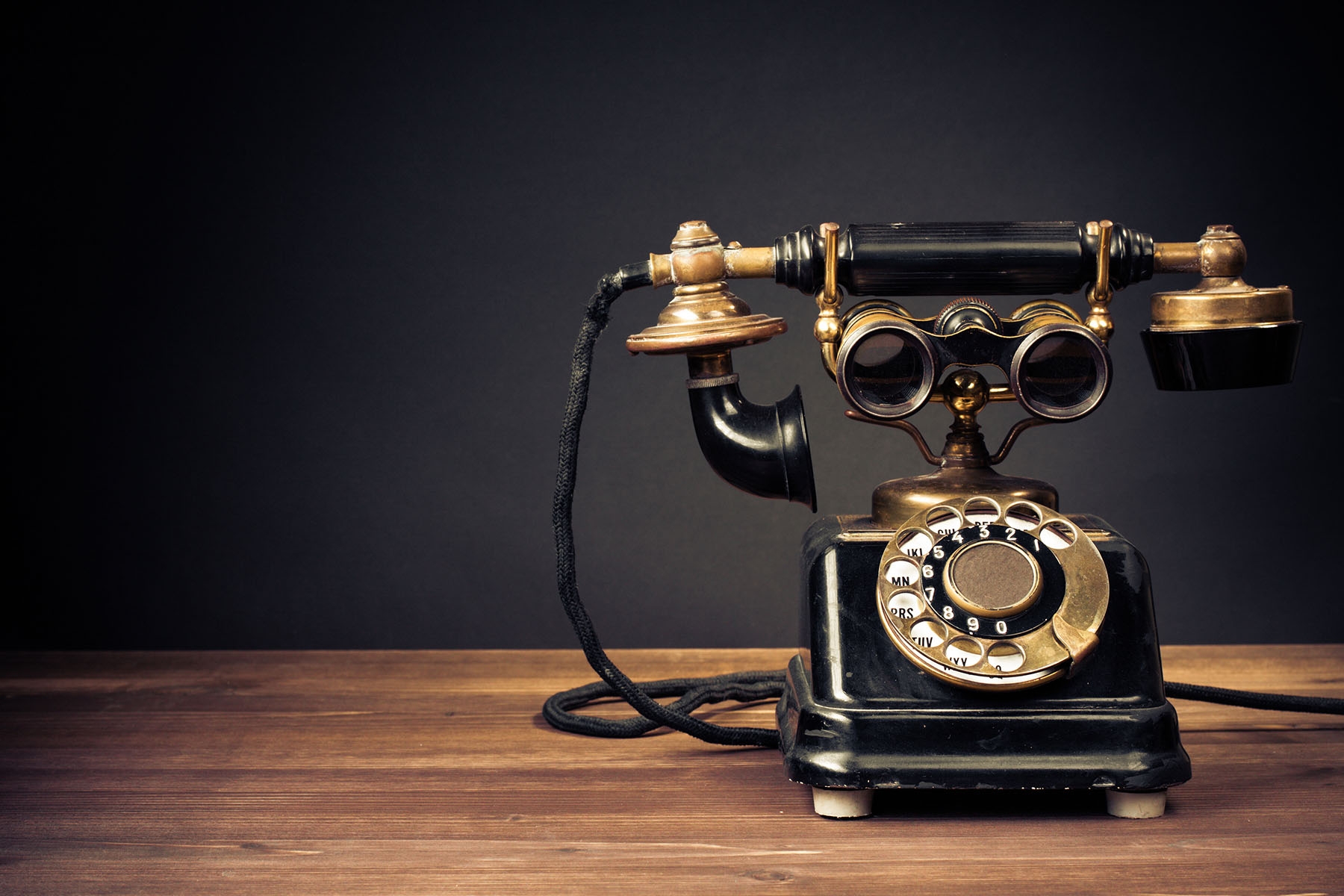 Vintage phone placed on wooden table.